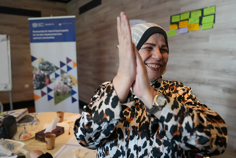 Image of a lady clapping her hands and smiling 